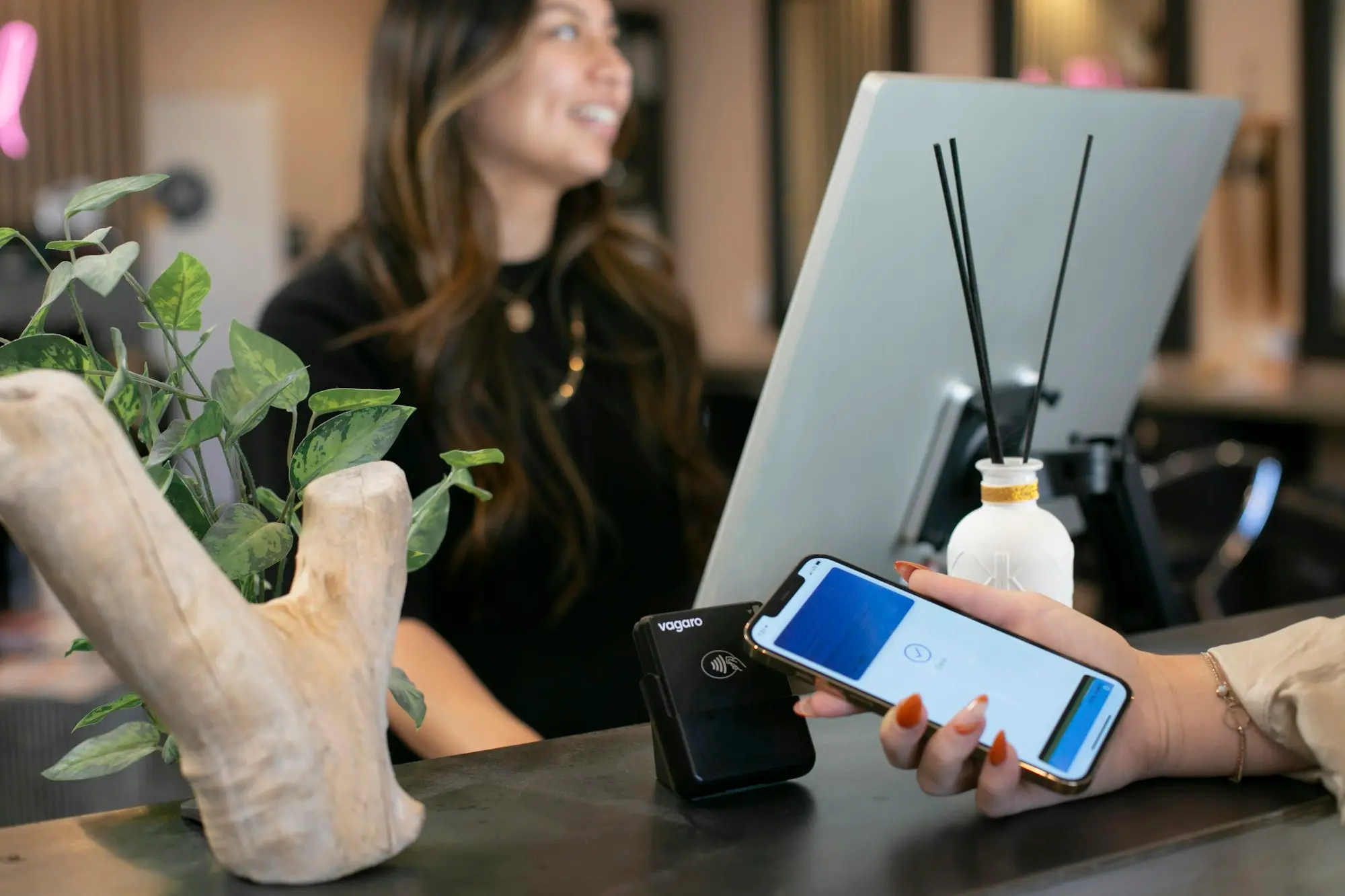 Customer paying by phone at a salon reception desk