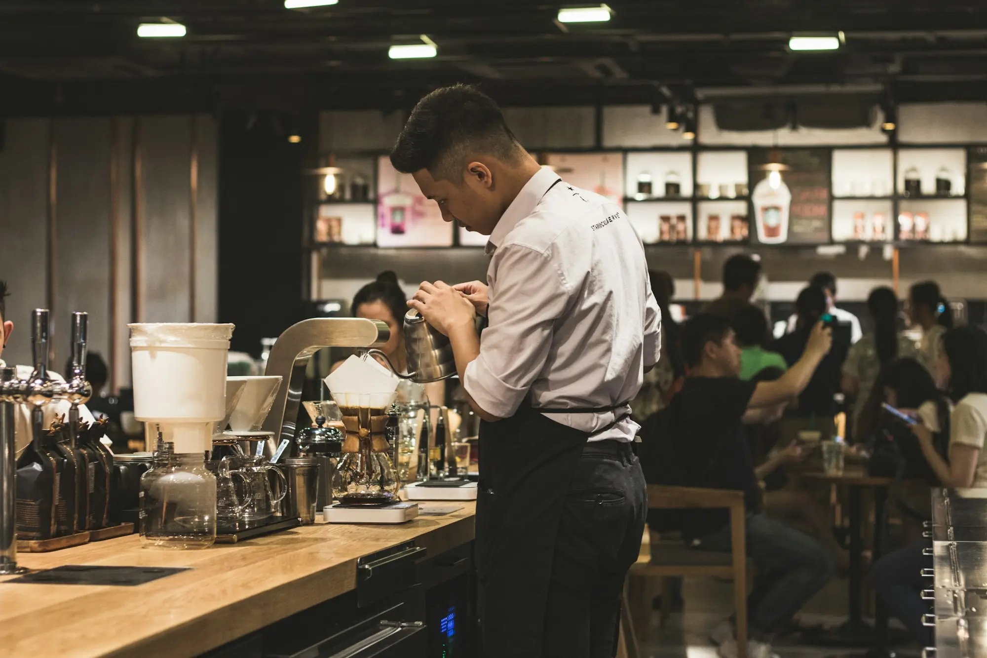 Cafe owner checking his phone behind the counter