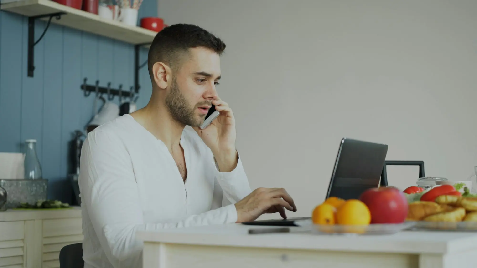 Business owner on the phone at his kitchen laptop after a loan decline