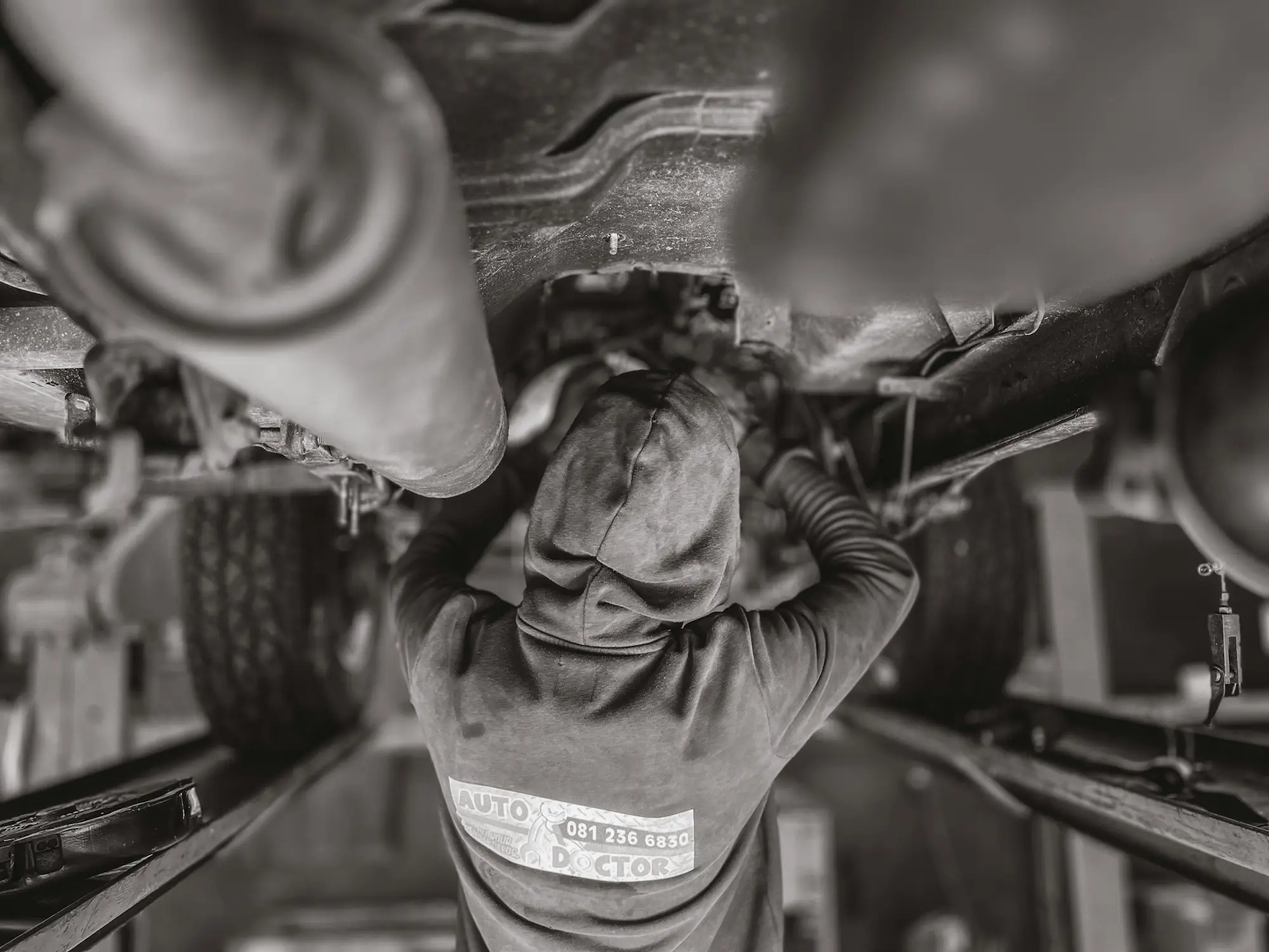 Mechanic working under a vehicle in a workshop