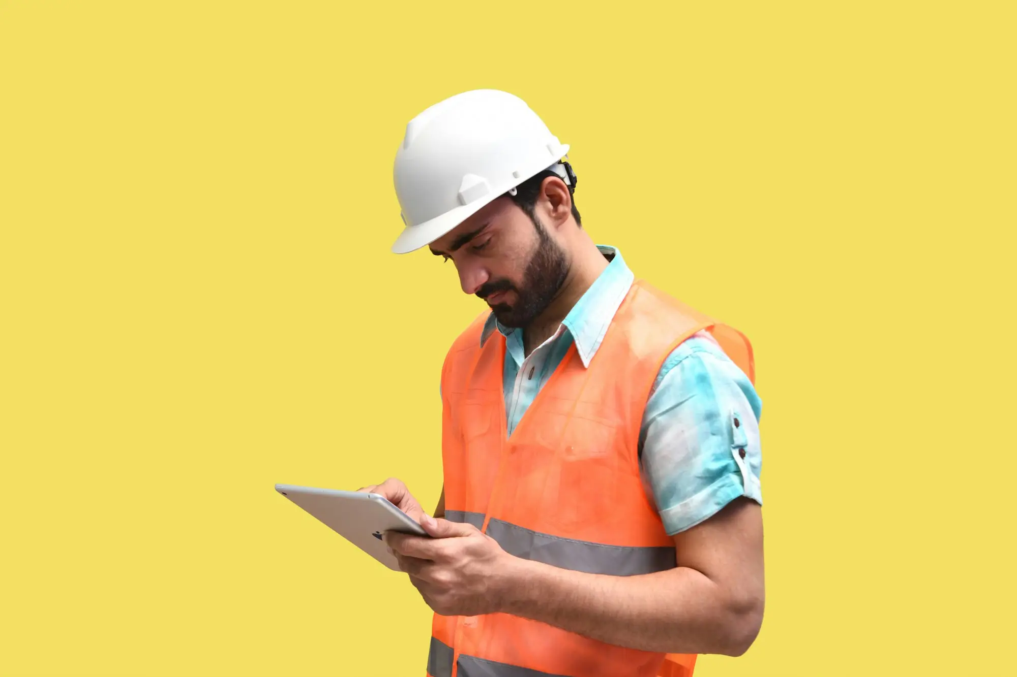 Tradie in a hard hat and hi-vis signing off on a tablet